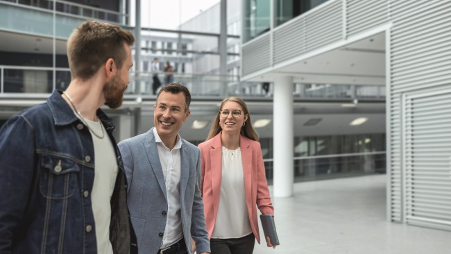 Three employees walking through a Commerzbank building