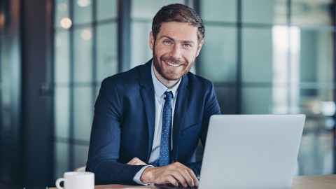 Young man sitting behind laptop